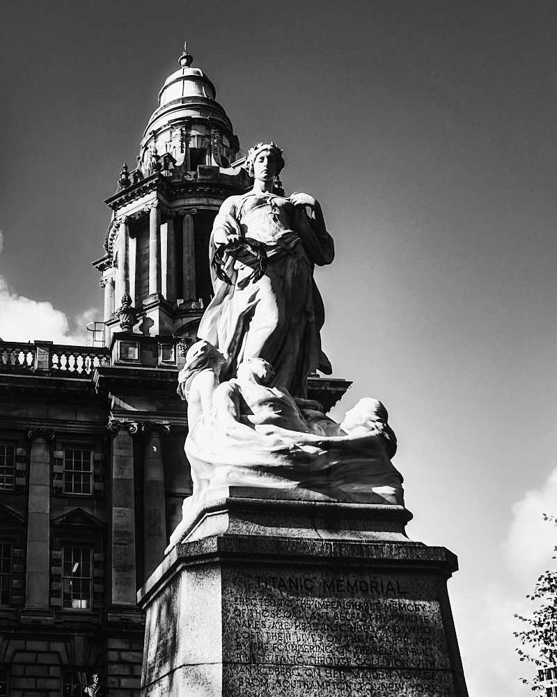 The Titanic Memorial statue in front of the dome of Belfast City Hall